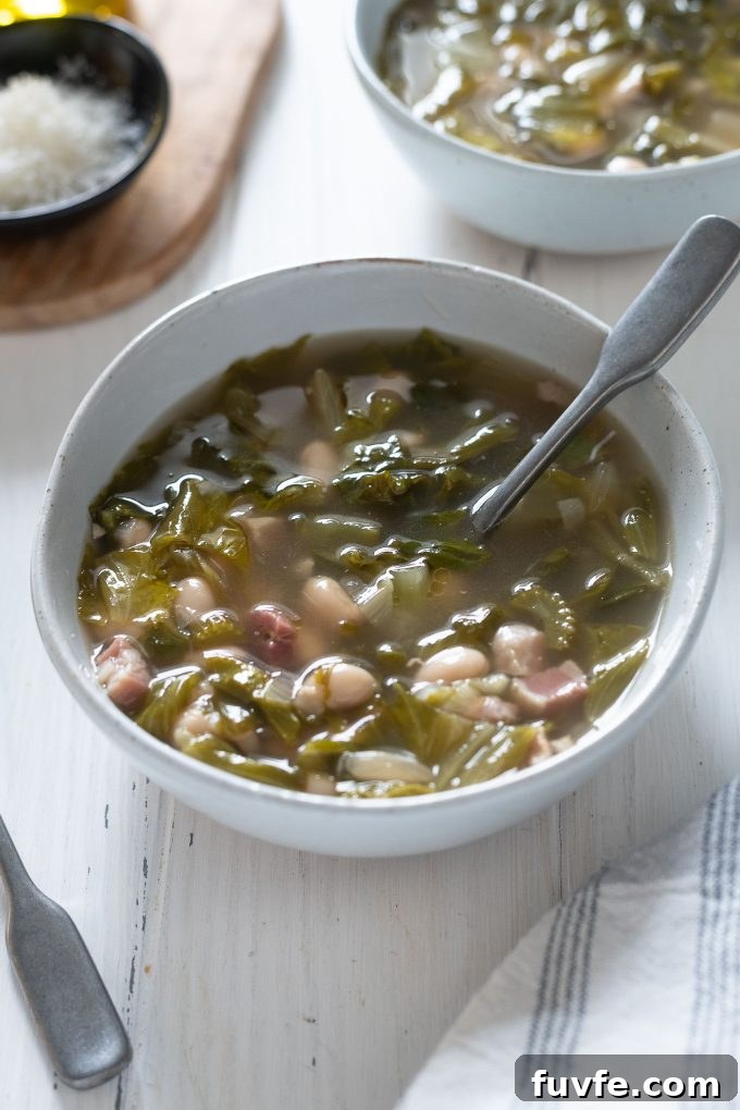 Bowl of escarole and bean soup with spoon buried inside