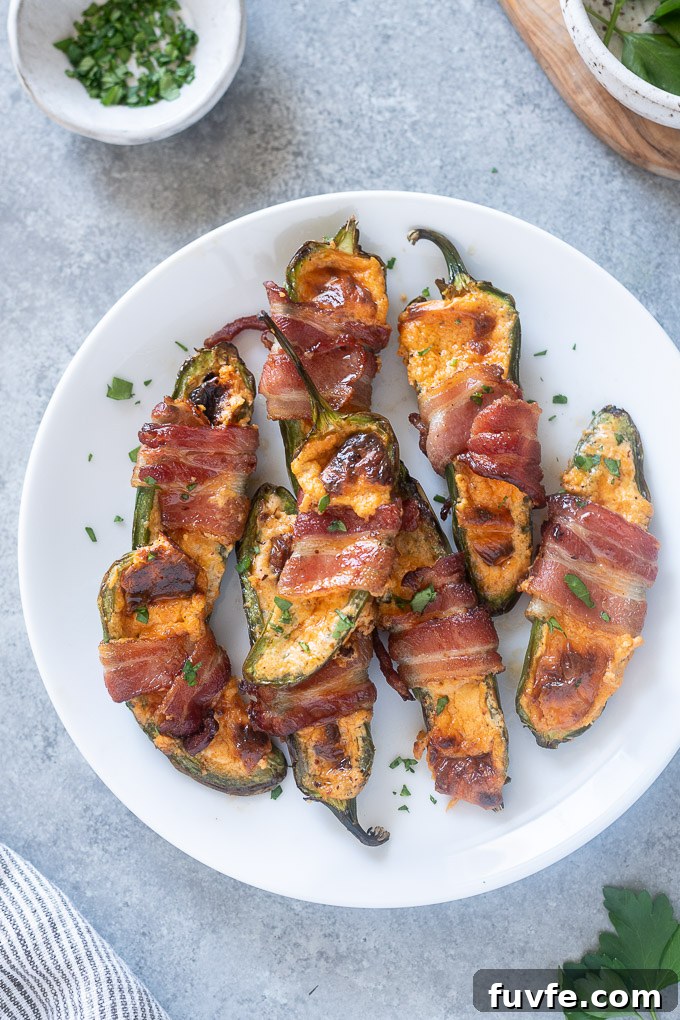 Crispy Air Fryer Jalapeño Poppers Recipe 3 Bacon wrapped jalapeno poppers on a white plate