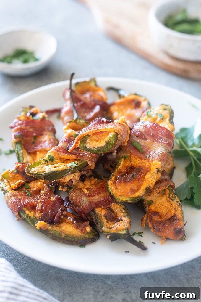 Crispy Air Fryer Jalapeño Poppers Recipe 8 Bacon wrapped jalapeno poppers piled on a plate