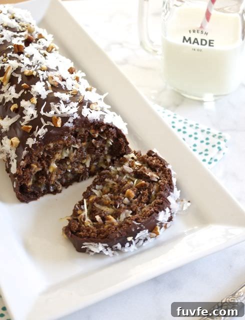 German chocolate roll cake with slice cut on white plate