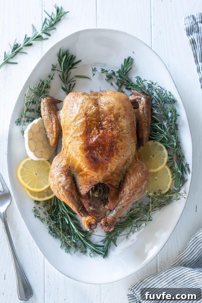 Roasted Lemon-Garlic Chicken with Crispy Skin 3 Easy Roasted chicken on a platter with lemon, garlic and rosemary