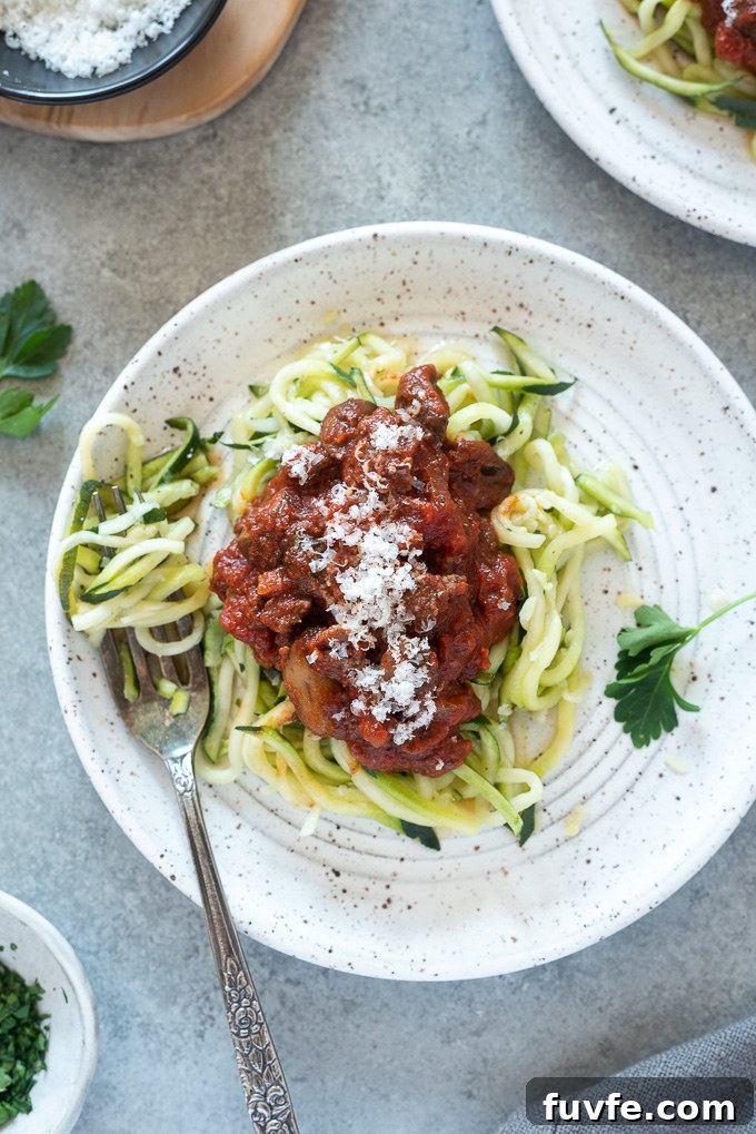 Meat sauce over zoodles on a white plate