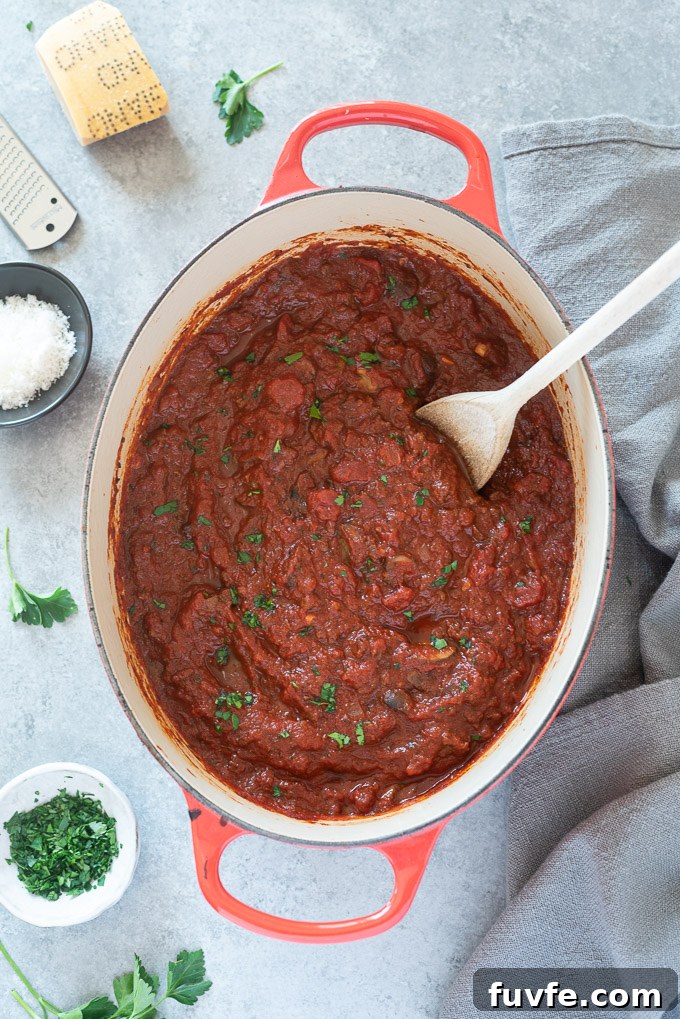 Classic Homemade Meat Sauce Recipe for Pasta 6 Meat sauce in a Dutch oven with a wooden spoon