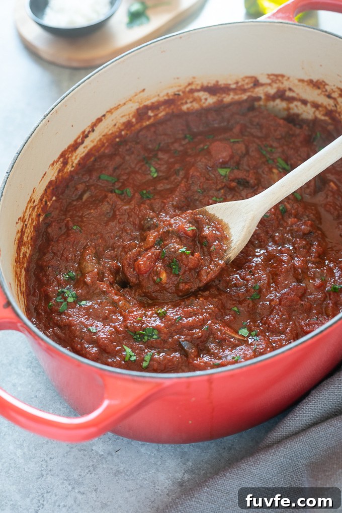 Classic Homemade Meat Sauce Recipe for Pasta 7 Wooden spoon full of meat sauce over a Dutch oven