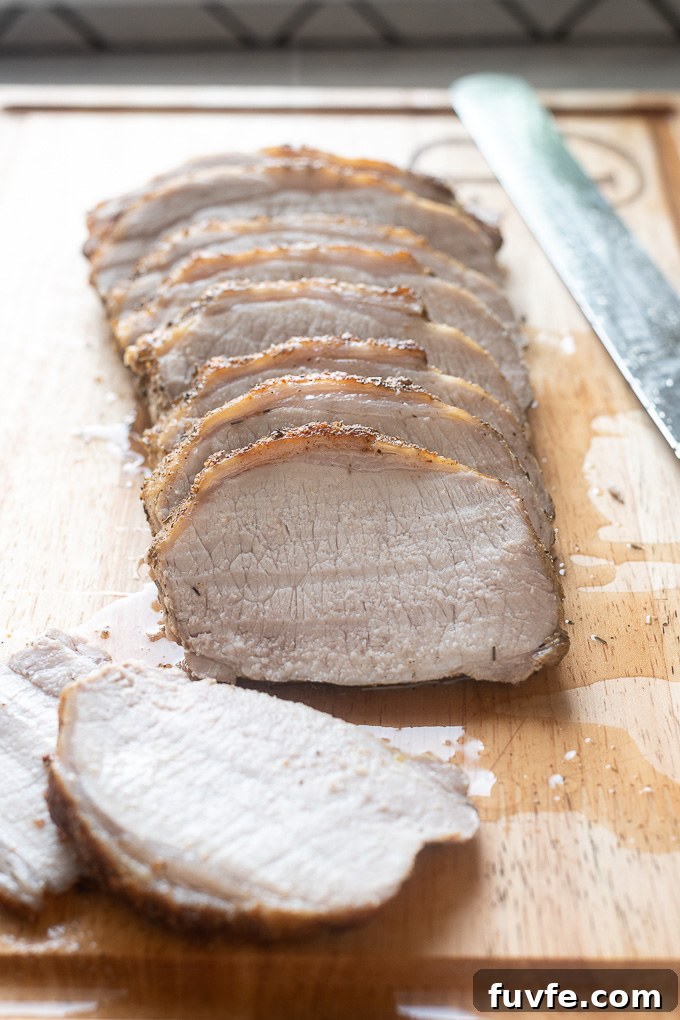 Roasted Pork Loin with Garlic and Rosemary 6 sliced pork loin roast on a cutting board