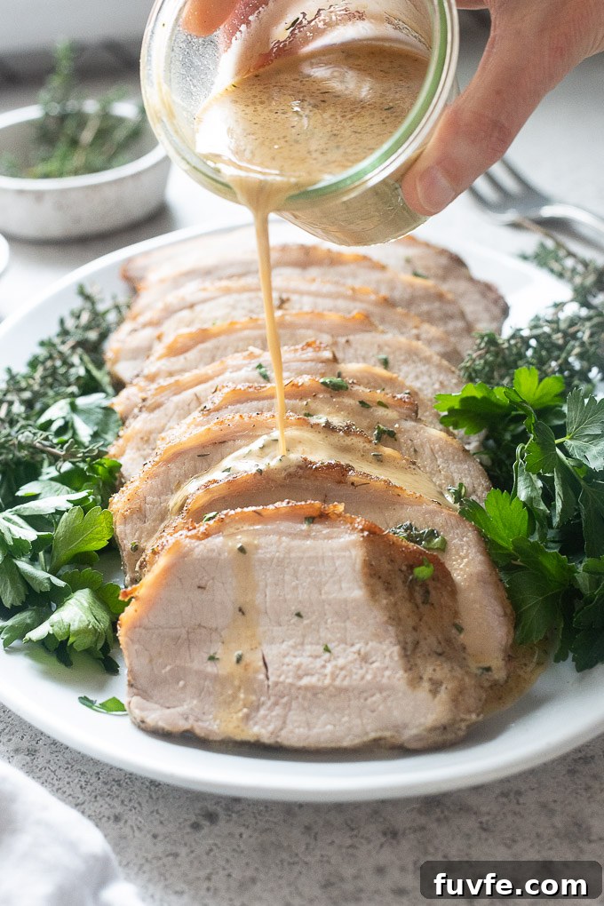 Roasted Pork Loin with Garlic and Rosemary 8 sliced pork loin roast with dijon cream sauce pouring over it