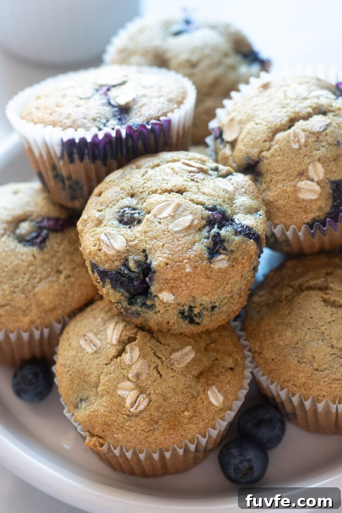 Blueberry oatmeal muffins piled on a plate.