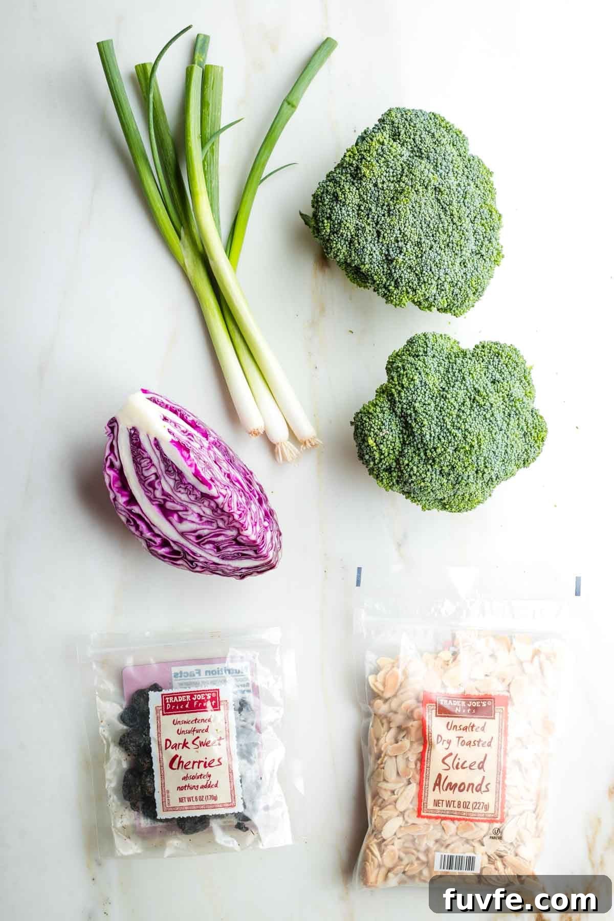 Crowns of broccoli, bunch of scallions, quarter head cabbage, package of dried cherries and sliced almonds.