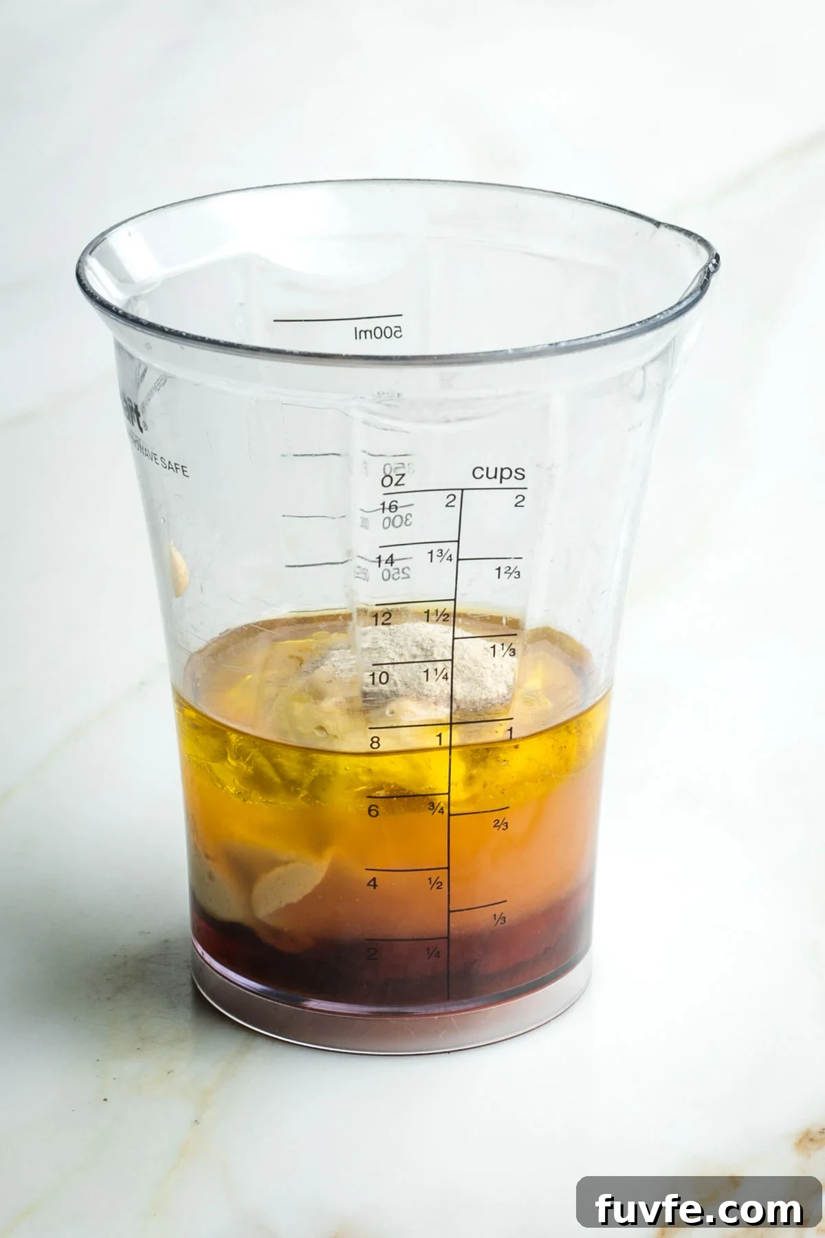 Blender cup with liquid ingredients including mustard and miso.