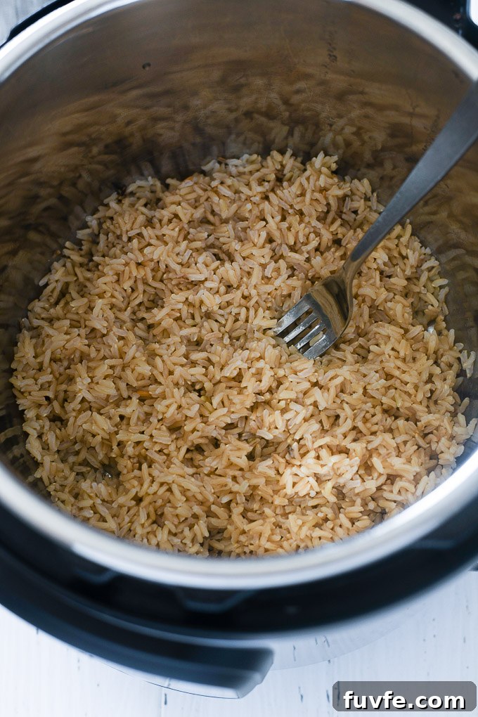 Fluffy Instant Pot Brown Rice in 20 Minutes 6 Fork fluffing brown rice in Instant Pot