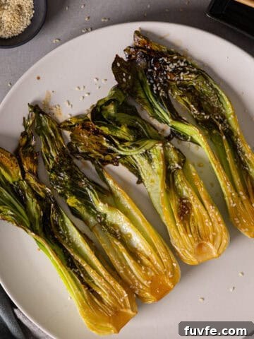 A platter of roasted bok choy lightly browned and garnished with sesame seeds.