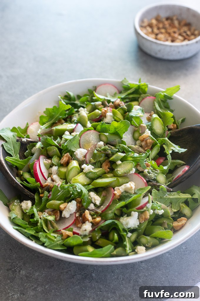 Cold asparagus salad tossed in a white bowl