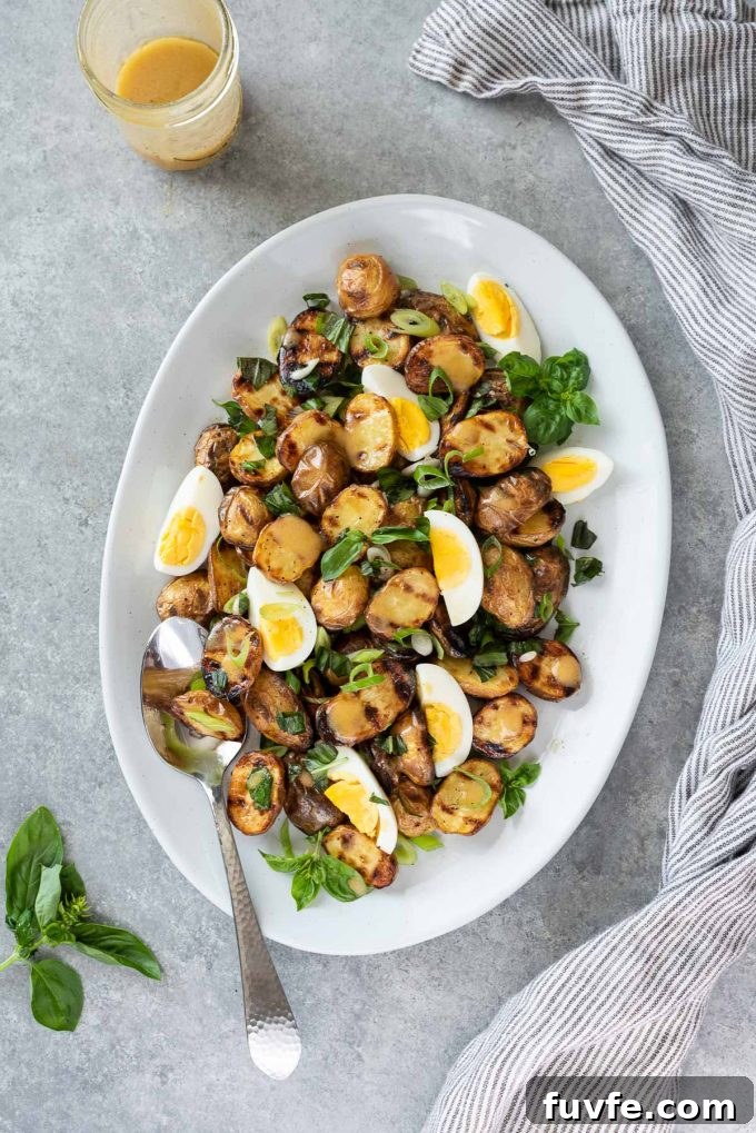 grilled potato salad on serving plate with fresh basil