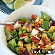 Simple BBQ Chicken Chopped Salad recipe in a large white bowl with a silver fork.