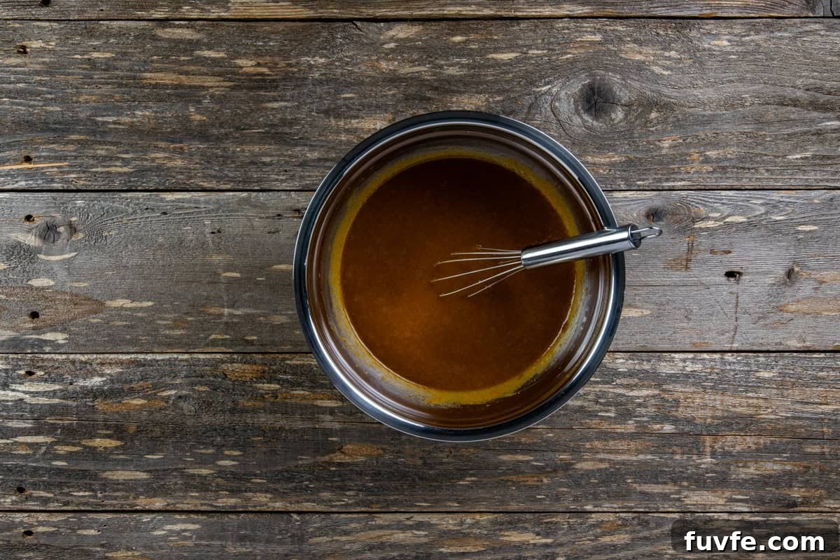 Eggs, vanilla, sugars, salt, baking soda, and pumpkin pie spice added to the bowl of pumpin puree mixture.