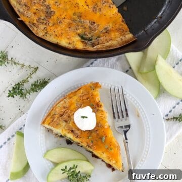 Apple Cheddar Frittata with Caramelized Onions and Herbs 10 a wedge slice of baked egg frittata with apples and cheddar cheese.