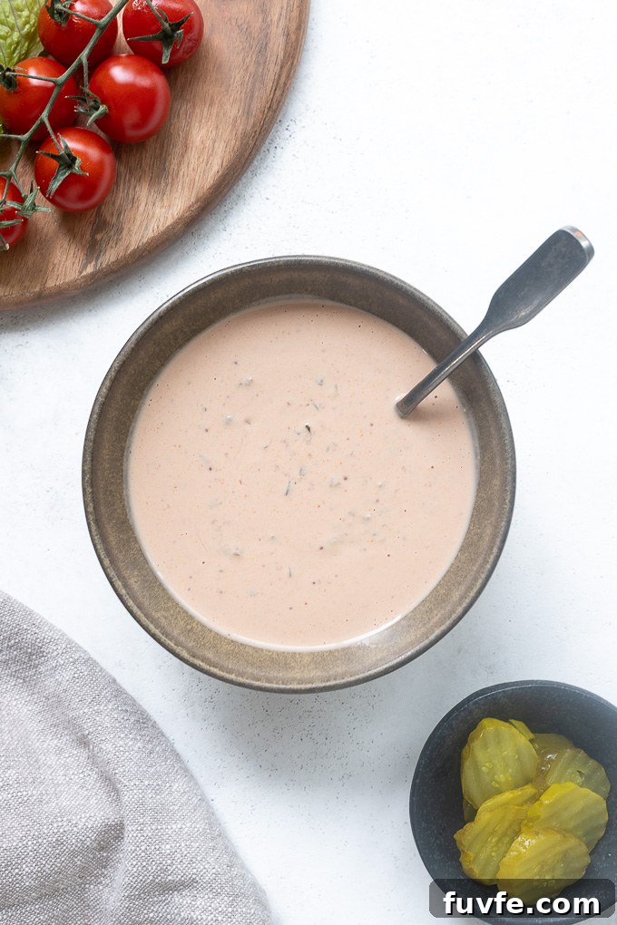 Creamy Tangy Burger Sauce Recipe for Juicy Burgers 3 Spoon buried in bowl of burger sauce