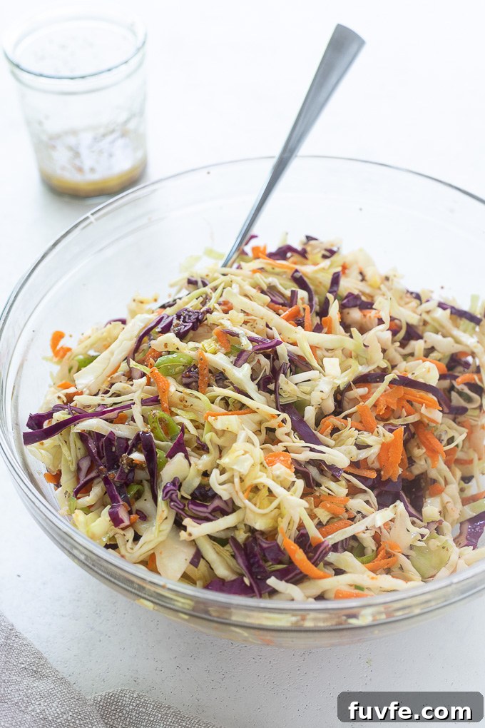 Vinegar Coleslaw in a glass bowl with a serving spoon
