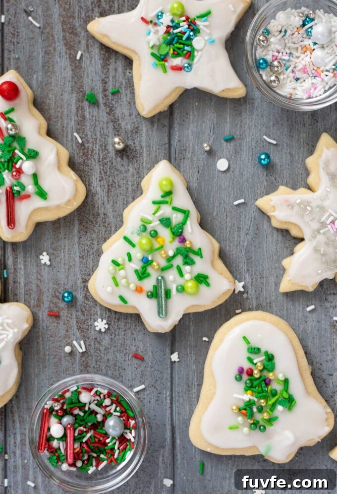 Cut out Christmas cookies with vanilla icing and shiny sprinkles.