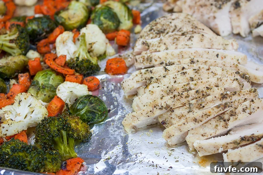 Sheet pan chicken and vegetables on a foil lined baking pan.