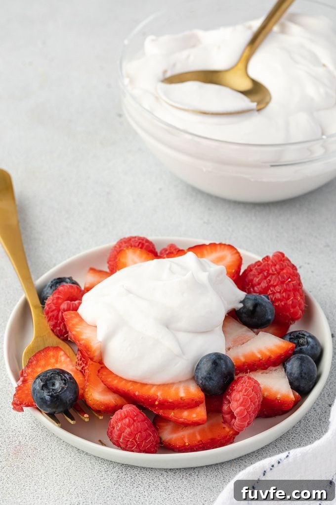 Coconut cream whipped cream over fresh berries.