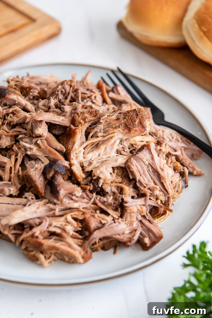 Crock pot pulled pork on a plate with a fork