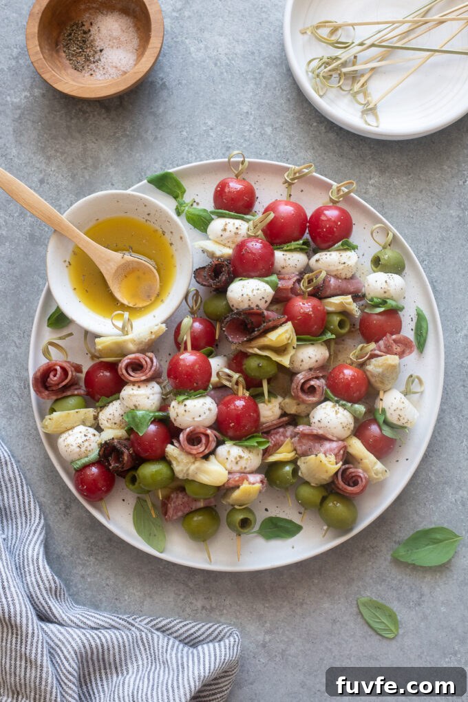 Antipasto skewers on a platter with Italian dressing.