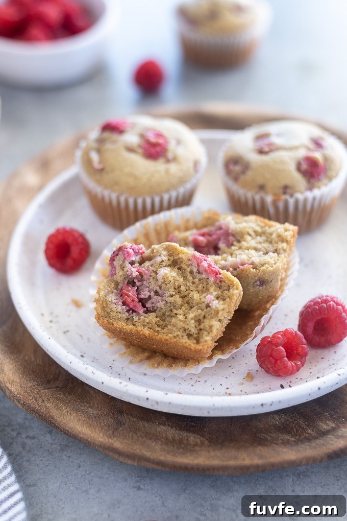 Raspberry muffins cut in half on a plate