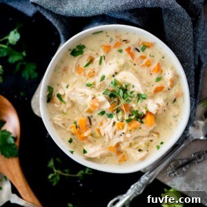 Creamy Chicken and Wild Rice Soup Recipe for Comforting Weeknights 11 Creamy chicken and rice soup in a bowl topped with parsley and thyme
