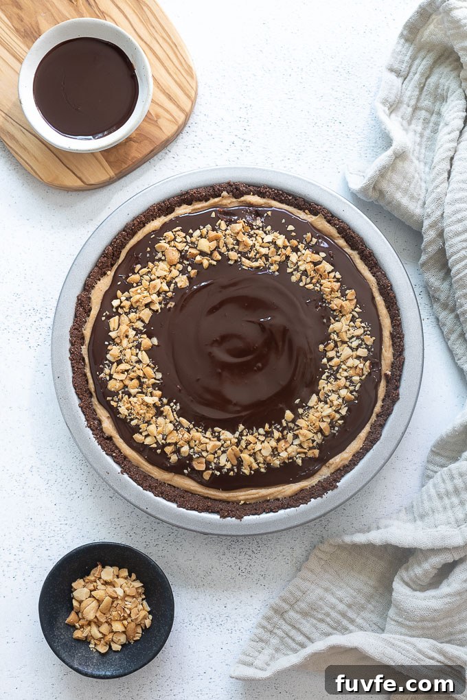 Chocolate peanut butter pie topped with chocolate ganache and peanuts