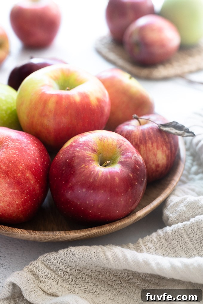 45 Apple Recipes with Complete Produce Guide 5 Apple fruits in a bowl with a linen