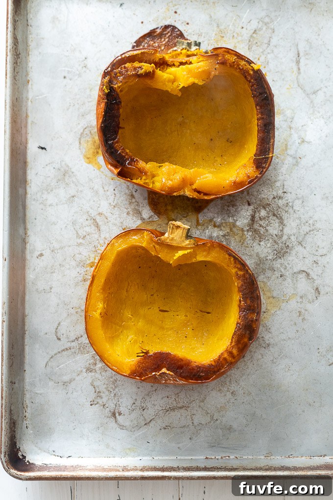 Roasted pumpkin halves on a baking sheet