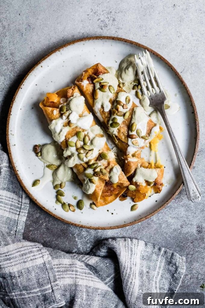 Pumpkin taquitos on a plate with crema.