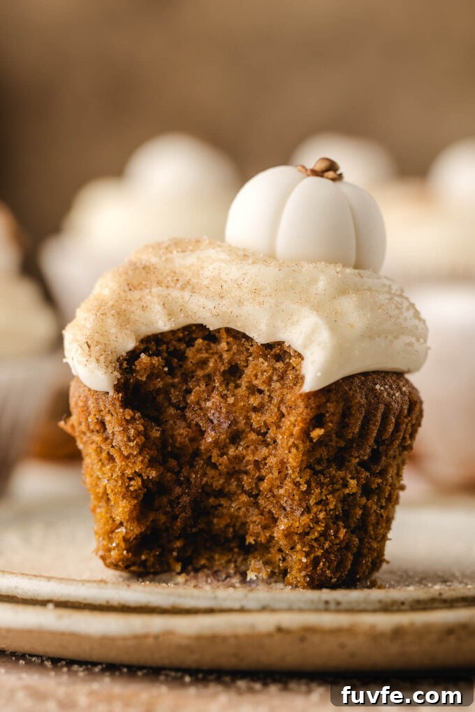 Pumpkin cupcake with bite taken out.