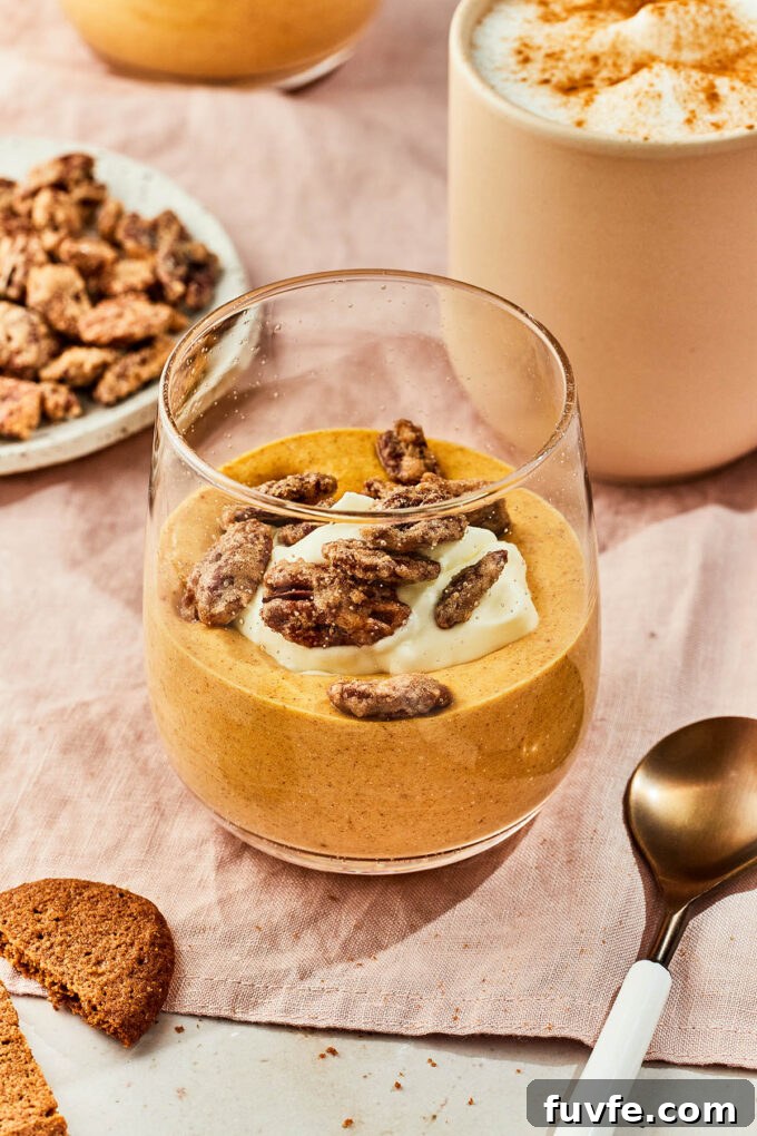Pumpkin mousse in a jar with whipped cream and pecans.