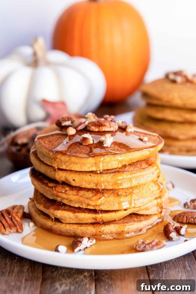 Stack of healthy pumpkin pancakes with pecans and syrup