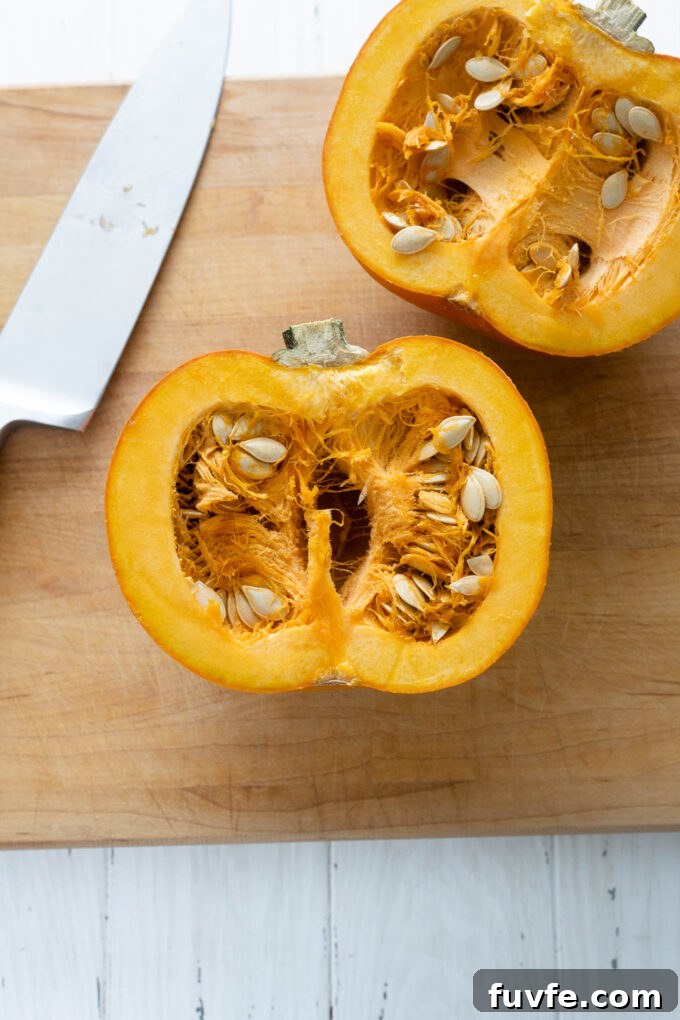 How to Cut a Pumpkin for Carving and Cooking 2 Pumpkin cut in half on a cutting board with knife