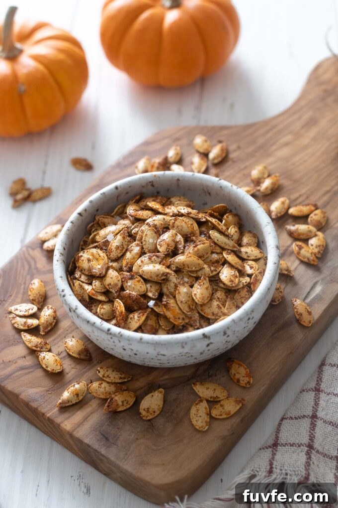Roasted pumpkin seeds in a bowl on a cutting board