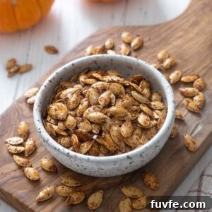 Roasted pumpkin seeds in a bowl on a cutting board