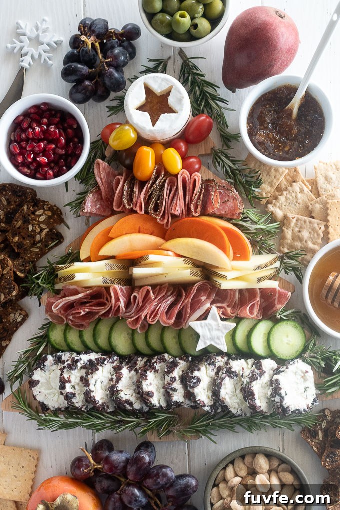 Christmas charcuterie board with crackers, jam, almonds and grapes surrounding it