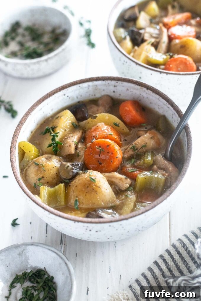 Chicken stew in a bowl with spoon digging in