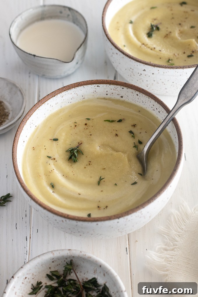 Creamy Roasted Parsnip Soup with Thyme 7 Bowl of creamy parsnip soup with a spoon buried inside