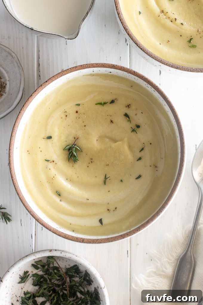 Creamy Roasted Parsnip Soup with Thyme 8 Bowl of parsnip soup with cream and thyme leaves