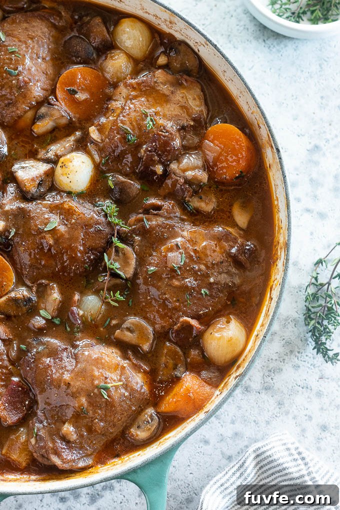 Classic Coq au Vin Recipe: French Red Wine Braised Chicken 7 Traditional coq au vin recipe in a pot with thyme