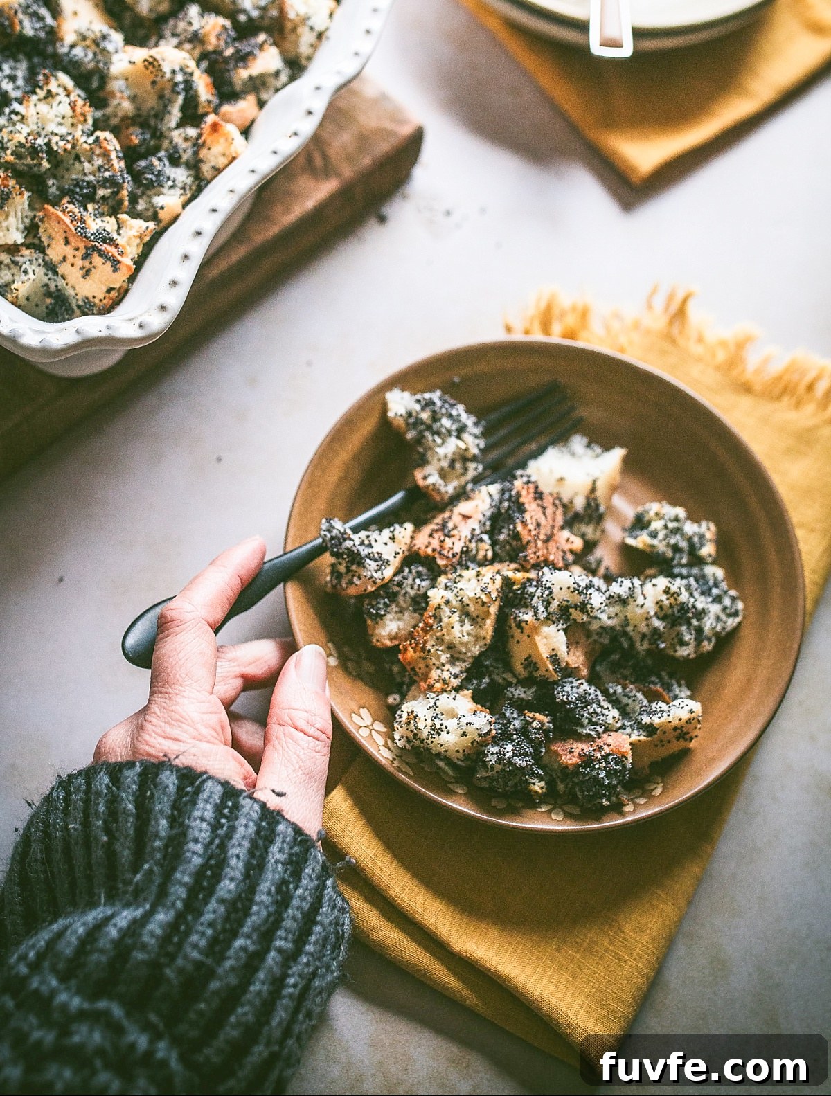 woman's hand holds spoon digging into a bowl of Mákos Guba