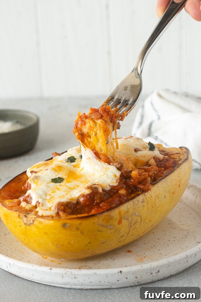 Fork pulling strands of spaghetti squash lasagna