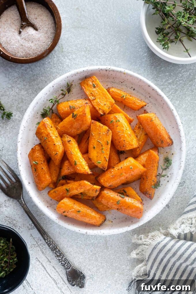 Air fryer carrots on a plate with thyme leaves
