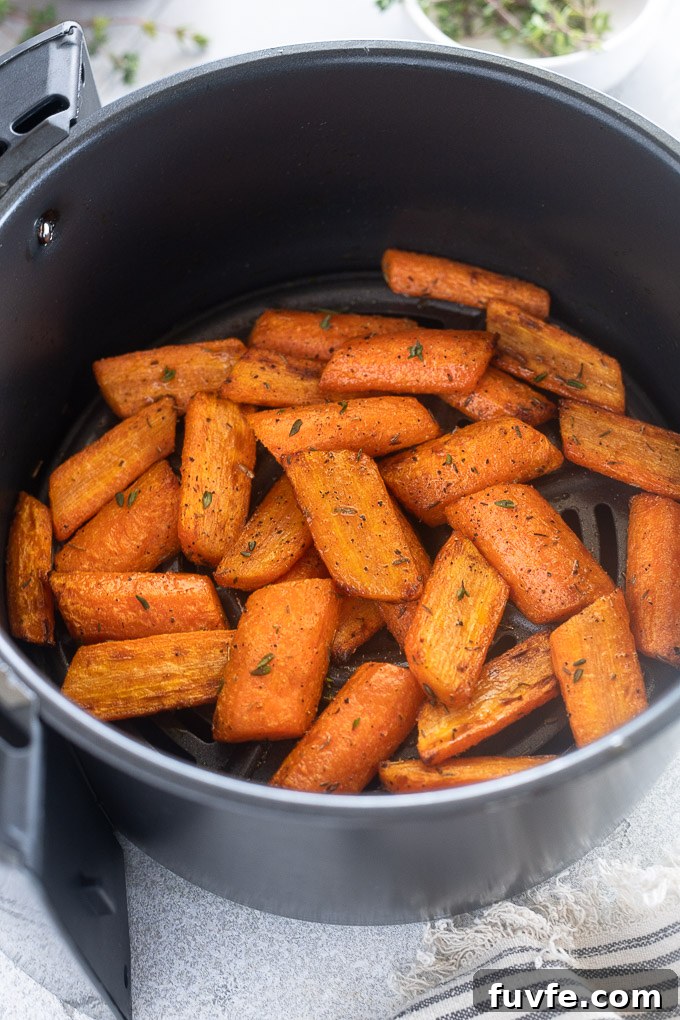 Roast carrots in air fryer with thyme leaves as a garnish.