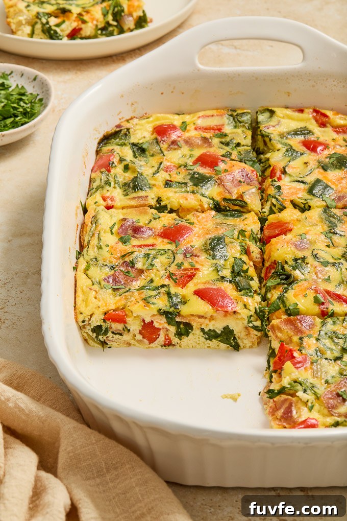 Egg bake with bacon cut into squares in baking dish.