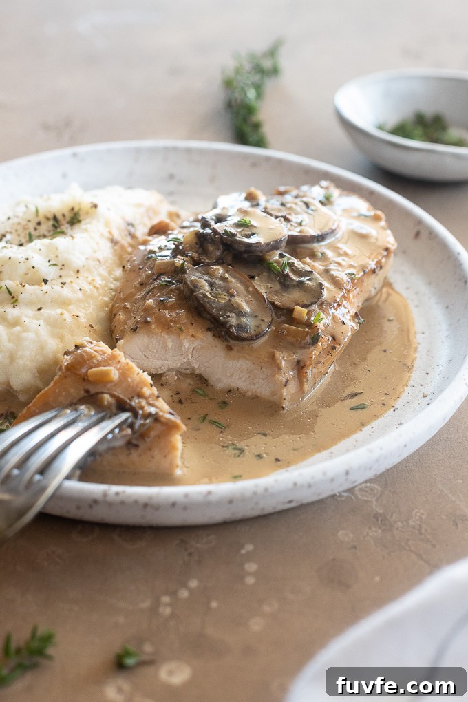 Creamy Chicken Marsala with Mushrooms 9 Marsala Chicken on a plate with a slice removed.